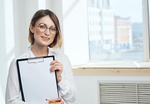 Cropped view of woman with folder of documents near window indoors. High quality photo
