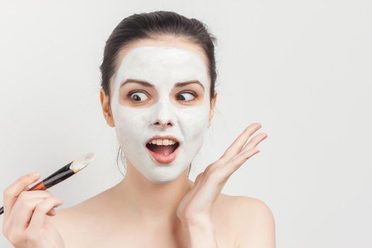 brunette naked shoulders face cream skin care. High quality photo