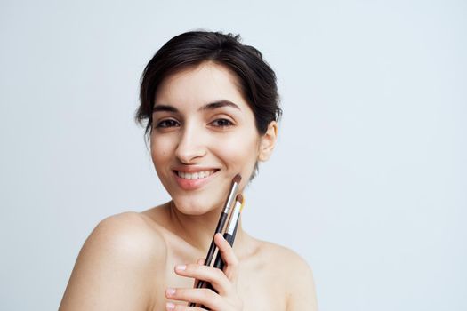 Pretty woman nude shoulders makeup brush cosmetics skin care. High quality photo