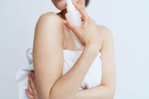 Pretty woman in white towel naked shoulders lotion clean skin hygiene. High quality photo
