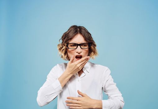 Emotional woman gestures with her hands on a blue background surprise Model shirt stress. High quality photo