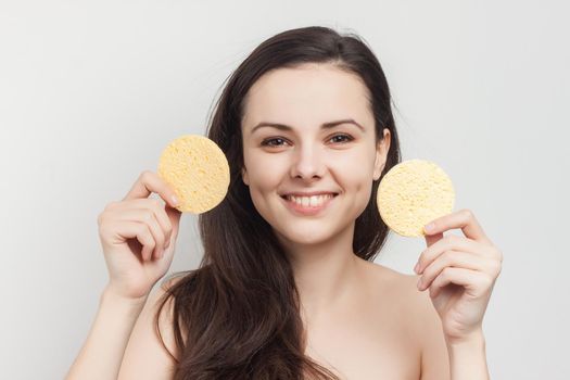 pretty brunette with bare shoulders sponge in hand grooming cropped view. High quality photo