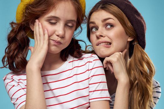 Cheerful girl and woman on a blue background sisters family emotions. High quality photo
