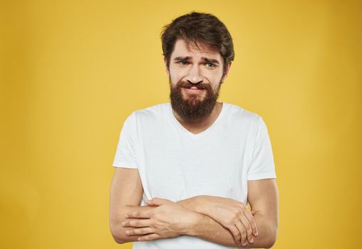The man has his arms crossed over his chest against a yellow background cropped view. High quality photo