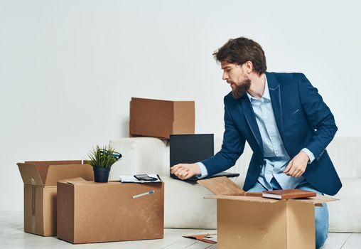 A man sits boxes with things unpacking a new professional job. High quality photo