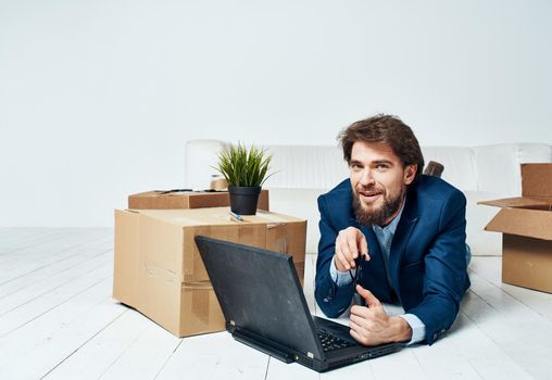 A man lies in front of a laptop boxes with things unpacking Office professional businessman. High quality photo