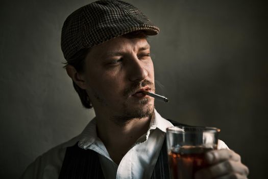 Young guy smoke a cigarette and drinks whiskey, blows smoke, dressed in a retro style, in a beret, cinematic shot, big closeup