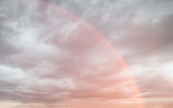Rainbow in the sky against dark dramatic clouds 
