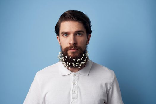 Man in white t-shirt beard flowers decoration blue background. High quality photo
