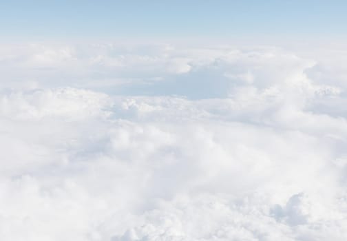 Sky with clouds, a view from an aeroplane above the clouds. Abstract nature background with clouds in light tonality. White cumulus clouds
