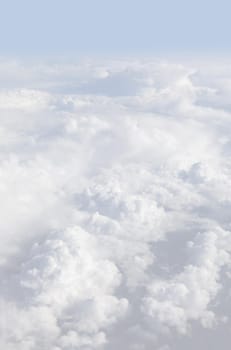 Sky with clouds, a view from an aeroplane above the clouds. Abstract nature background with clouds in light tonality. White cumulus clouds