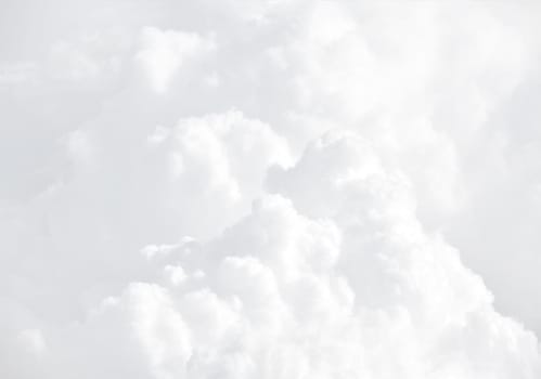 Sky with clouds, a view from an aeroplane above the clouds. Abstract nature background with clouds in light tonality. White cumulus clouds