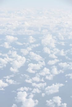 Sky with clouds, a view from an aeroplane above the clouds. Abstract nature background with clouds in light tonality. White cumulus clouds
