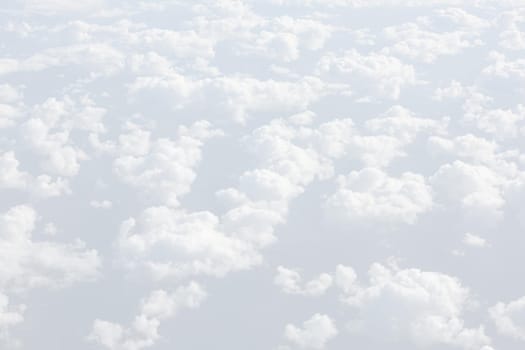 Sky with clouds, a view from an aeroplane above the clouds. Abstract nature background with clouds in light tonality. White cumulus clouds