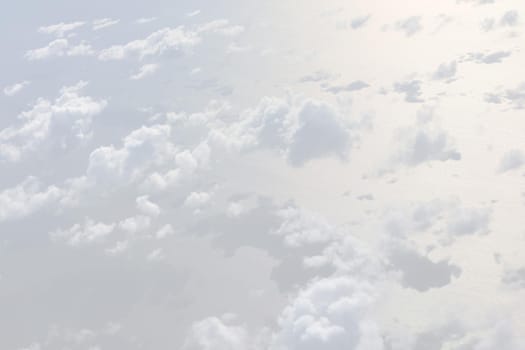 Sky with clouds, a view from an aeroplane above the clouds. Abstract nature background with clouds in light tonality. White cumulus clouds