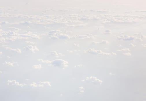 Sky with clouds, a view from an aeroplane above the clouds. Abstract nature background with clouds in light tonality. White cumulus clouds
