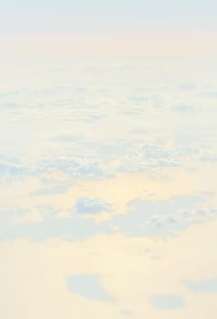 Sky with clouds, a view from an aeroplane above the clouds. Abstract nature background with clouds in light tonality. White cumulus clouds