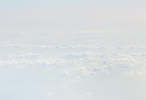 Sky with clouds, a view from an aeroplane above the clouds. Abstract nature background with clouds in light tonality. White cumulus clouds