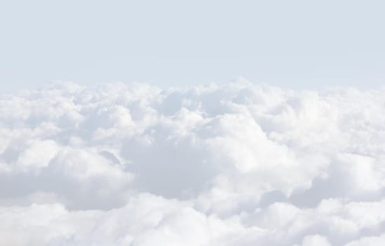 Sky with clouds, a view from an aeroplane above the clouds. Abstract nature background with clouds in light tonality. White cumulus clouds