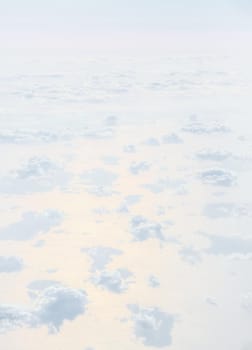 Sky with clouds, a view from an aeroplane above the clouds. Abstract nature background with clouds in light tonality. White cumulus clouds