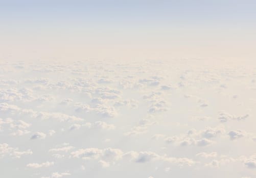 Sky with clouds, a view from an aeroplane above the clouds. Abstract nature background with clouds in light tonality. White cumulus clouds