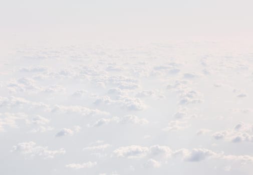 Sky with clouds, a view from an aeroplane above the clouds. Abstract nature background with clouds in light tonality. White cumulus clouds