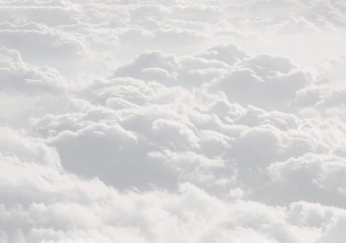 Sky with clouds, a view from an aeroplane above the clouds. Abstract nature background with clouds in light tonality. White cumulus clouds