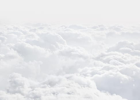 Sky with clouds, a view from an aeroplane above the clouds. Abstract nature background with clouds in light tonality. White cumulus clouds
