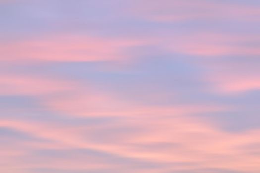 Blurry shot of the sunset sky. Abstract nature background with clouds in light tonality. 