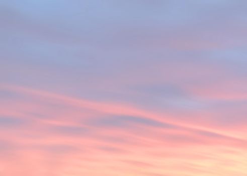 Blurry shot of the sunset sky. Abstract nature background with clouds in light tonality. 