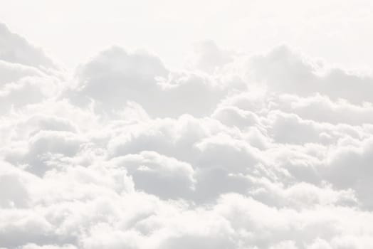 Sky with clouds, a view from an aeroplane above the clouds. Abstract nature background with clouds in light tonality. White cumulus clouds