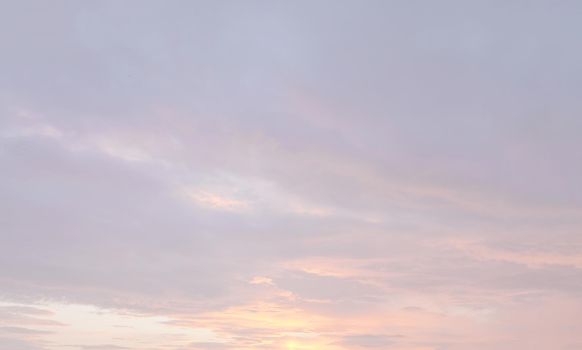 Blurry shot of the sunset sky. Abstract nature background with clouds in light tonality. 