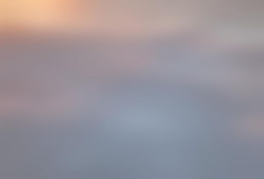 Blurry shot of the sunset sky. Abstract nature background with clouds in light tonality. 