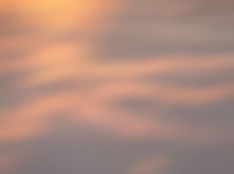 Blurry shot of the sunset sky. Abstract nature background with clouds in light tonality. 