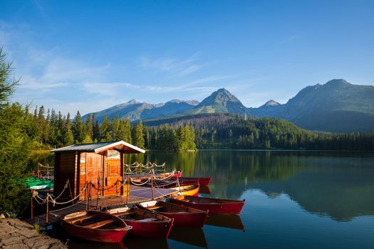 Red boats on mountain lake in National Park High Tatra. Strbske pleso, Slovakia, Europe