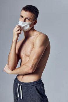 athletic man with muscular body medical mask black shorts . High quality photo
