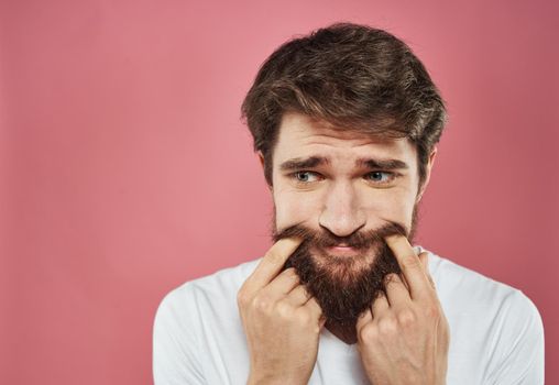 Man emotions sadness white t-shirt pink background. High quality photo