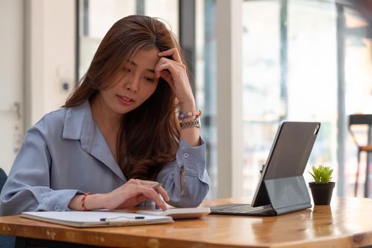 businesswoman working on desk office with using a calculator to calculate the numbers, finance accounting concept