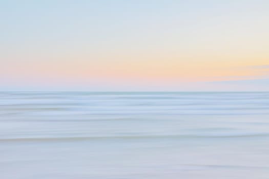Abstract blurred sea landscape and cloudy sky background in light tonality with copy space