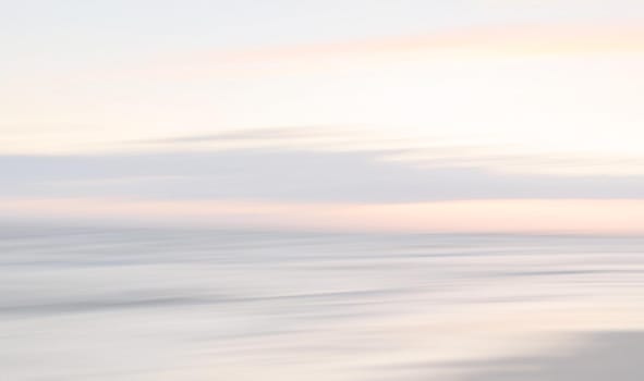 Abstract blurred sea landscape and cloudy sky background in light tonality with copy space