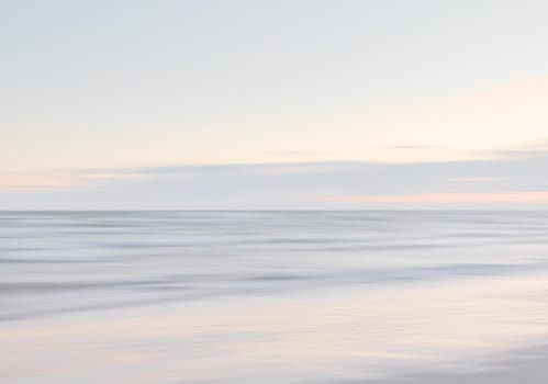 Abstract blurred sea landscape and cloudy sky background in light tonality with copy space