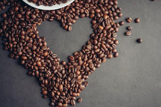 coffee beans on a gray background and a hot aromatic drink on a saucer top view. High quality photo