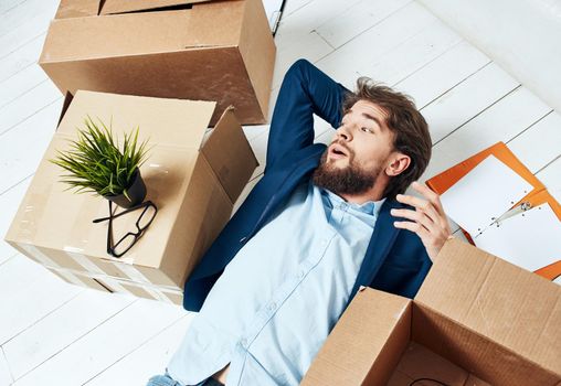 man lying on the floor with documents office box with things professional unpacking. High quality photo