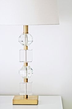 Lamp with gold and crystal design in white interior, luxury home decor concept