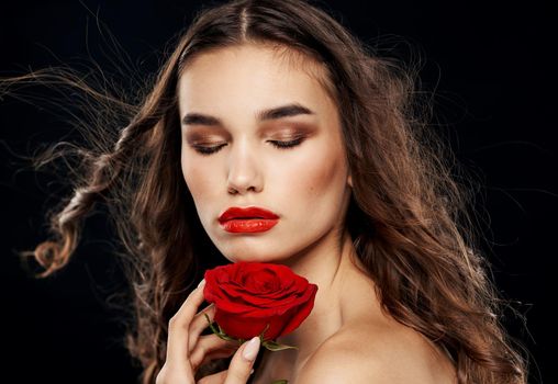 Charming woman with red rose eyeshadow bright makeup black background. High quality photo