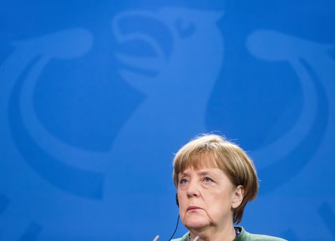 BERLIN, GERMANY - Jan 30, 2017: Chancellor of the Federal Republic of Germany Angela Merkel against of Germany coat of arms Imperial Eagle. Joint briefing with President of Ukraine Petro Poroshenko
