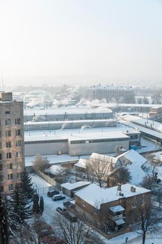 The factory chimneys are smoking during a winter season. The concept of air pollution. Environmental pollution by industrial waste