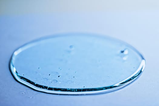 Blue gel texture on glass as cosmetics background, hygiene and science closeup