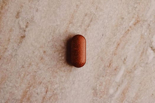 Medical pill on stone background, health and wellness closeup