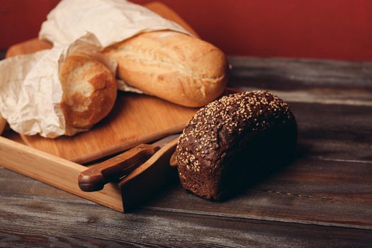 flour products rye bread on a tray and a sharp knife on the table. High quality photo